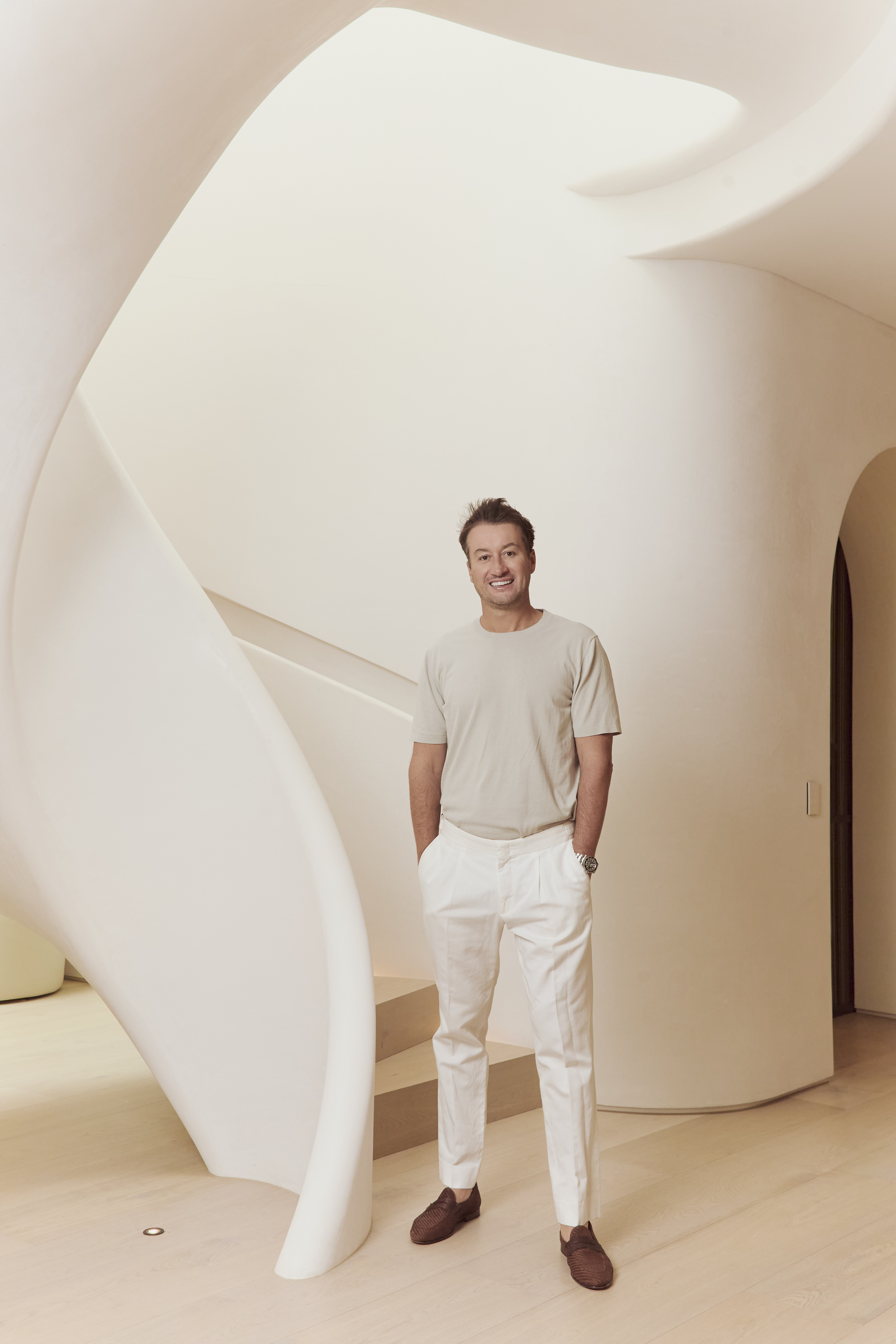 Shaun Wilson, Founder of Sol Rise Partners and former CEO of Bondi Sands, standing beside a sculptural staircase